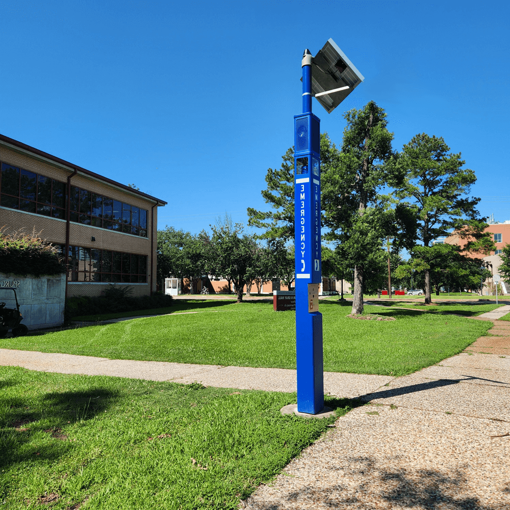 Large blue towers with blue light along sidewalk